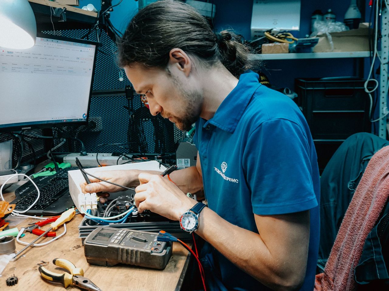 Technician repairing hardware at a workbench
